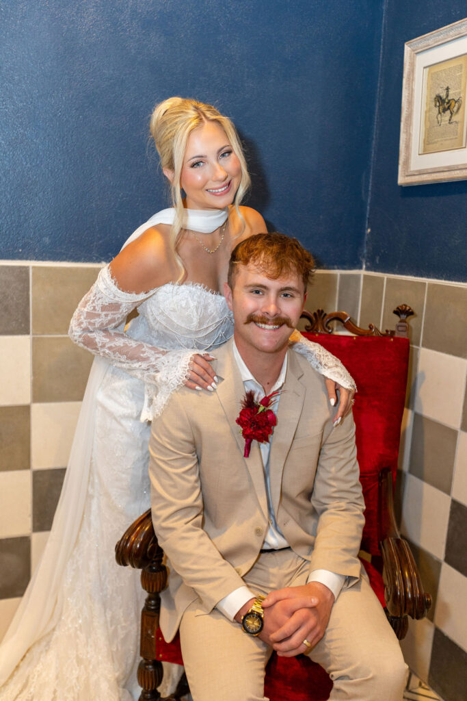 Couple sitting on chair with black and white tiles in the background