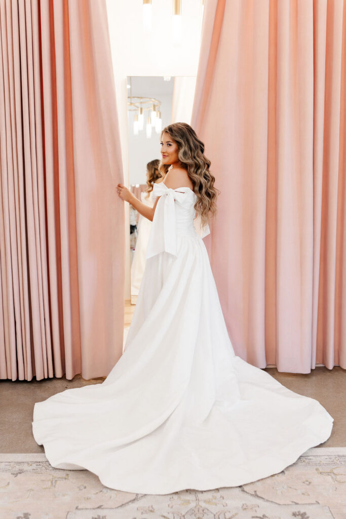 Grace Manor Events Bride stand in front of big pink curtains