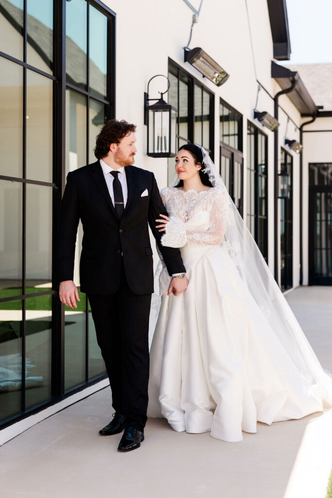 Couple walking in front of black doors at the Grace Manor Wedding Venue in DFW