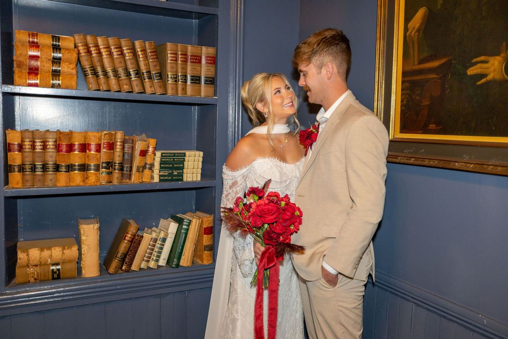 Sierah and Connor sitting together in a vintage library-inspired room at The Jazz Chapel
